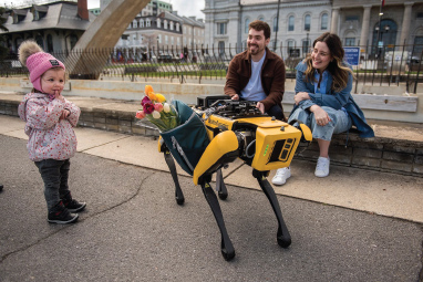 students with robot and small child in downtown Kingston