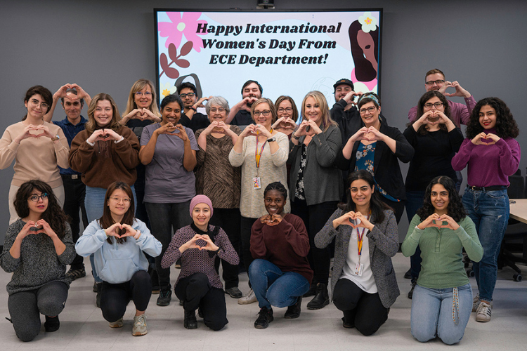 group photo of women in front of a sign saying Happy International Women's Day from the ECE Department 