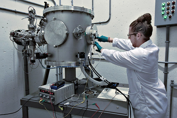 A researcher loads a target sample into the temperature-controlled chamber of the RMTL accelerator